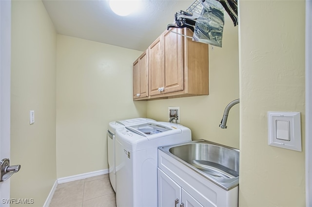 clothes washing area featuring baseboards, a sink, cabinet space, independent washer and dryer, and light tile patterned floors