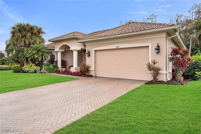 mediterranean / spanish-style home featuring a garage and a front lawn