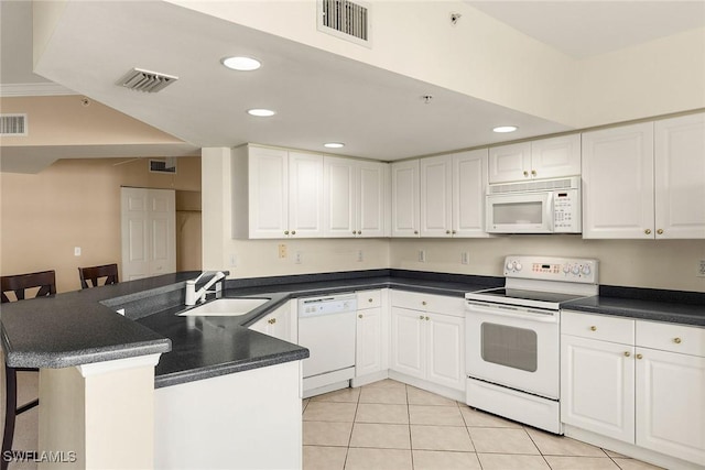 kitchen featuring white cabinetry, a breakfast bar area, white appliances, and kitchen peninsula