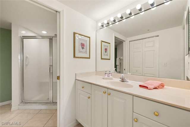 bathroom with vanity, a shower with shower door, and tile patterned floors