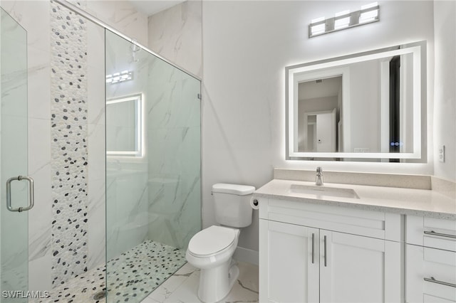 bathroom featuring vanity, a shower with door, and toilet