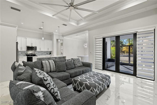 living room with crown molding, sink, and a notable chandelier