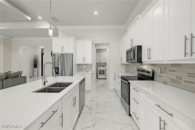 kitchen featuring white cabinetry, sink, hanging light fixtures, stainless steel appliances, and light stone countertops