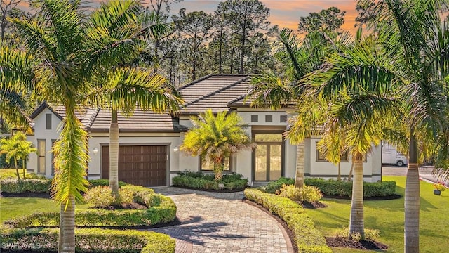 view of front of home with a garage and a yard