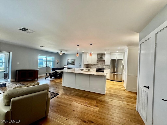 kitchen featuring sink, hanging light fixtures, stainless steel appliances, light stone countertops, and white cabinets