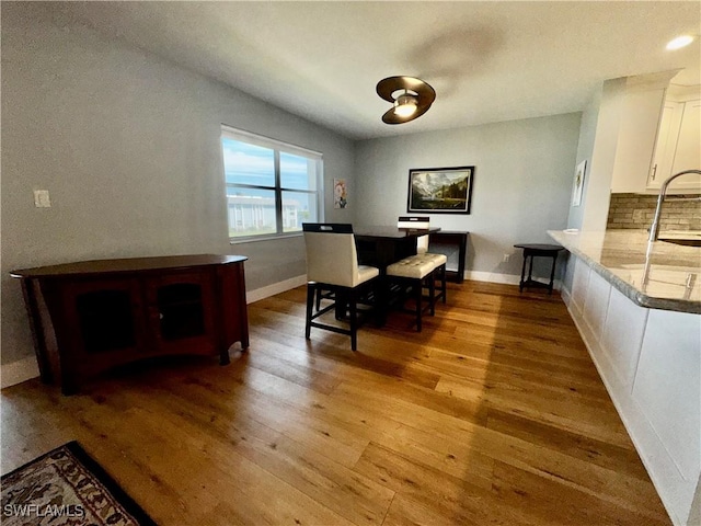 dining area with light hardwood / wood-style floors and sink