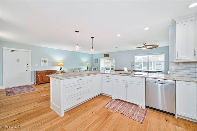 kitchen featuring dishwasher, sink, kitchen peninsula, and white cabinets