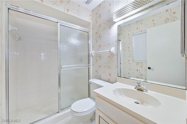 bathroom featuring vanity, a shower with shower door, and toilet