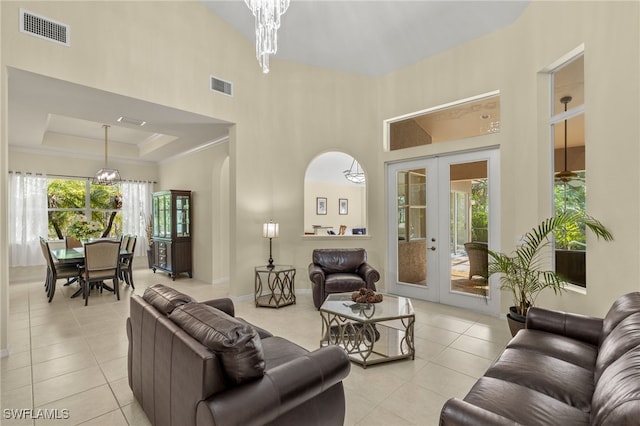 living room with french doors, a raised ceiling, a chandelier, and light tile patterned floors