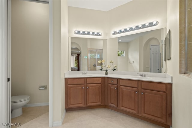 bathroom featuring tile patterned floors, toilet, a shower with shower door, and vanity