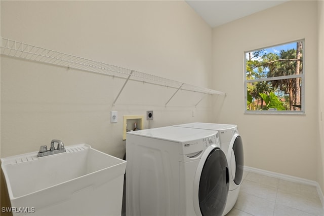 washroom with separate washer and dryer, sink, and light tile patterned flooring