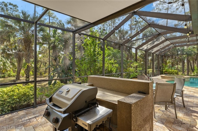 view of patio with grilling area, a swimming pool with hot tub, and glass enclosure