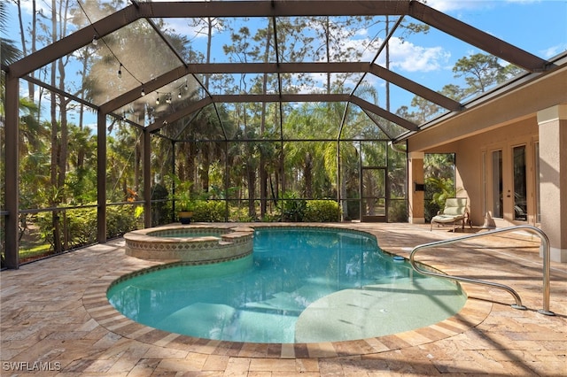 view of pool with an in ground hot tub, glass enclosure, and a patio area