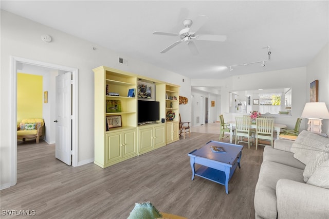 living room featuring wood-type flooring and ceiling fan