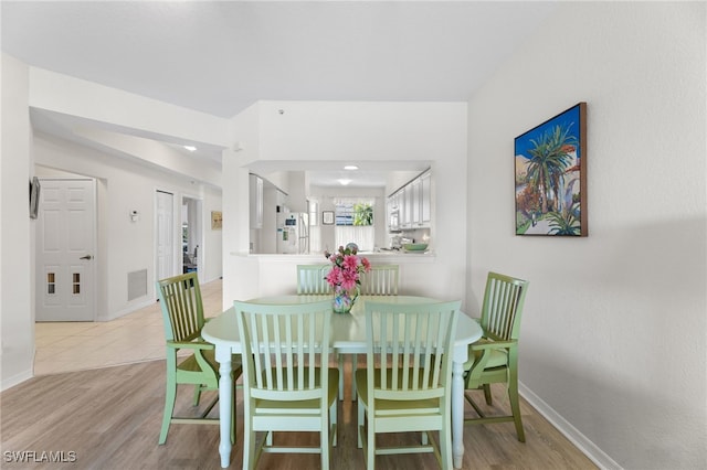 dining space with light hardwood / wood-style flooring