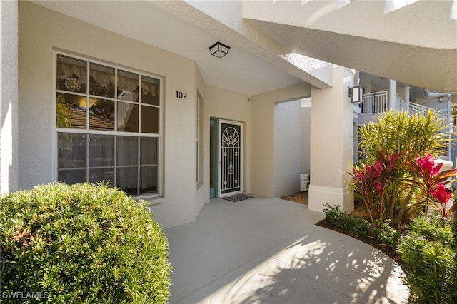 view of exterior entry with a patio