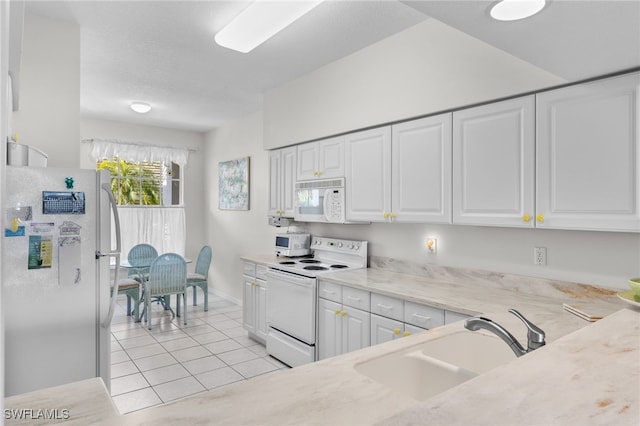 kitchen featuring sink, white appliances, light tile patterned floors, white cabinetry, and light stone counters