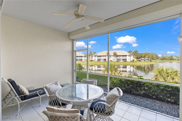 sunroom / solarium with a water view and ceiling fan