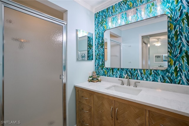 bathroom featuring a shower with door, crown molding, vanity, and ceiling fan