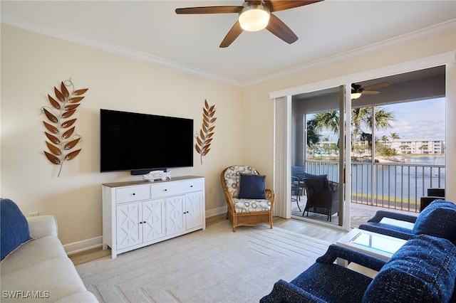 living area featuring ornamental molding, light wood-type flooring, baseboards, and a ceiling fan