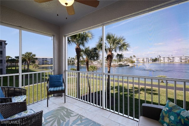 unfurnished sunroom with a water view and ceiling fan