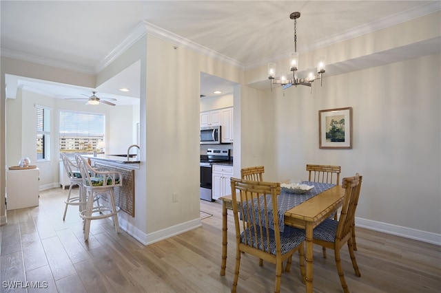 dining area featuring an inviting chandelier, sink, ornamental molding, and light hardwood / wood-style floors