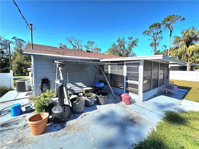 rear view of house with a sunroom, central AC unit, and a patio area