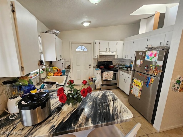 kitchen featuring sink, light tile patterned floors, stainless steel appliances, decorative backsplash, and white cabinets