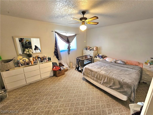 carpeted bedroom featuring ceiling fan and a textured ceiling