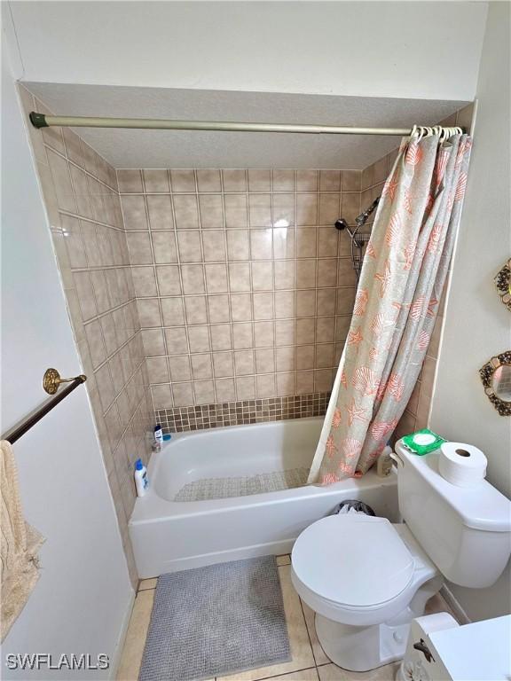 bathroom with tile patterned flooring, shower / bath combination with curtain, and toilet