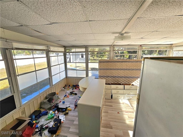 unfurnished sunroom with a drop ceiling