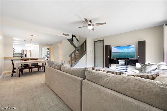 carpeted living room with ceiling fan