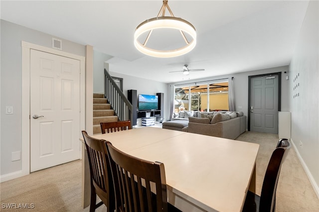 carpeted dining area featuring ceiling fan