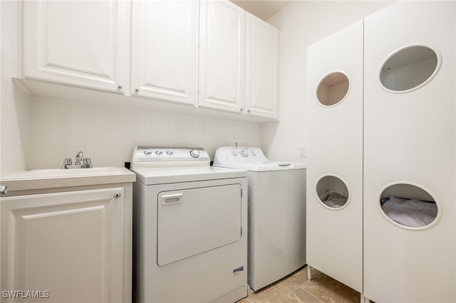 washroom featuring cabinets, sink, and washer and clothes dryer