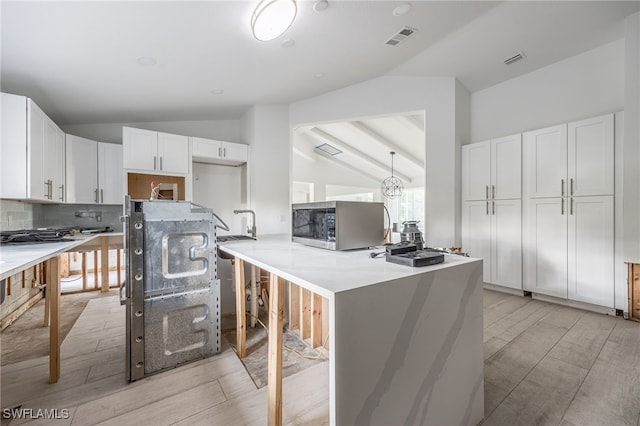 kitchen with lofted ceiling, white cabinets, decorative backsplash, light hardwood / wood-style floors, and kitchen peninsula