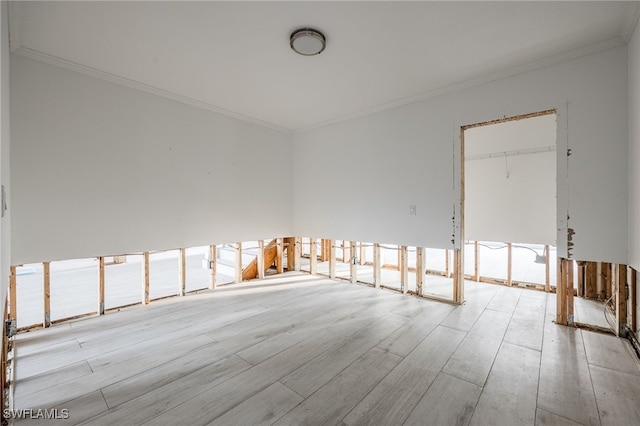 unfurnished room with ornamental molding and light wood-type flooring