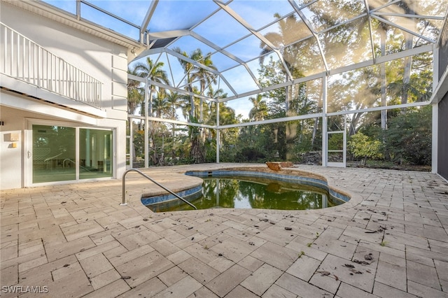 view of pool with a patio and glass enclosure