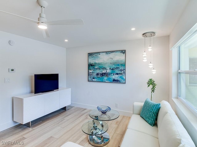 living room featuring ceiling fan and light hardwood / wood-style flooring