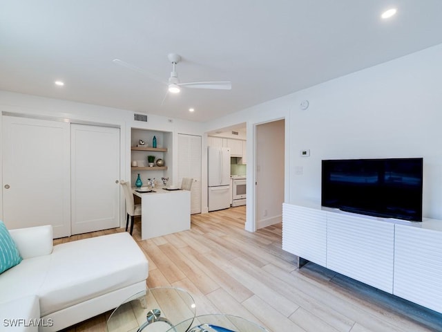 living room featuring ceiling fan and light hardwood / wood-style flooring