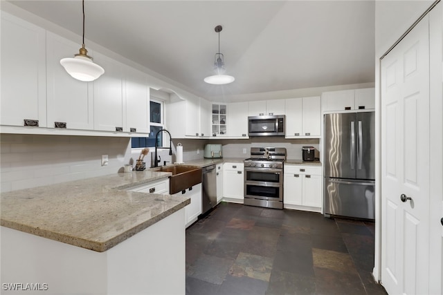 kitchen with white cabinetry, hanging light fixtures, kitchen peninsula, stainless steel appliances, and light stone countertops