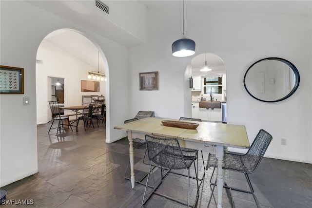 dining space featuring high vaulted ceiling and sink