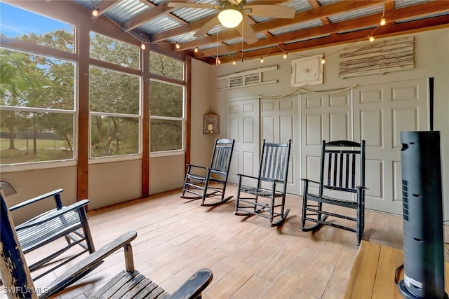 sunroom / solarium featuring beam ceiling and ceiling fan