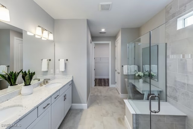 bathroom with vanity and a shower with door