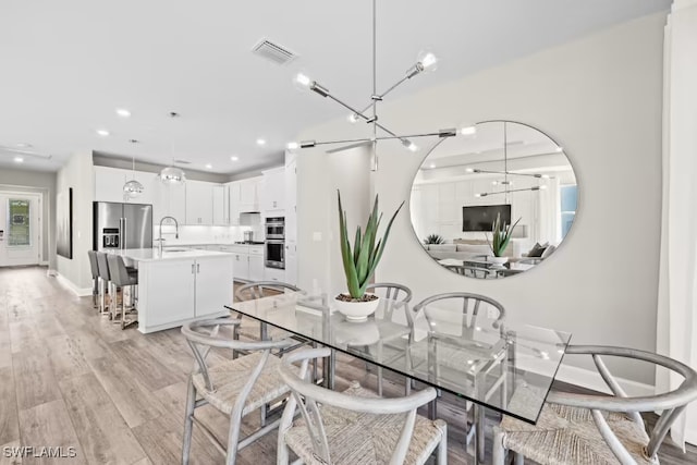 dining room with sink and light hardwood / wood-style flooring