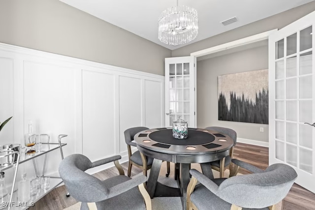 dining area featuring wood-type flooring and a notable chandelier