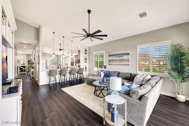 living room with dark hardwood / wood-style flooring, sink, and ceiling fan