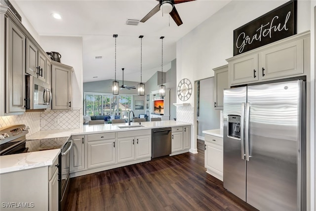 kitchen featuring dark hardwood / wood-style floors, decorative light fixtures, sink, decorative backsplash, and stainless steel appliances