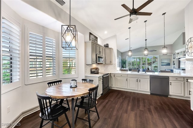 kitchen featuring stainless steel appliances, sink, decorative light fixtures, and kitchen peninsula