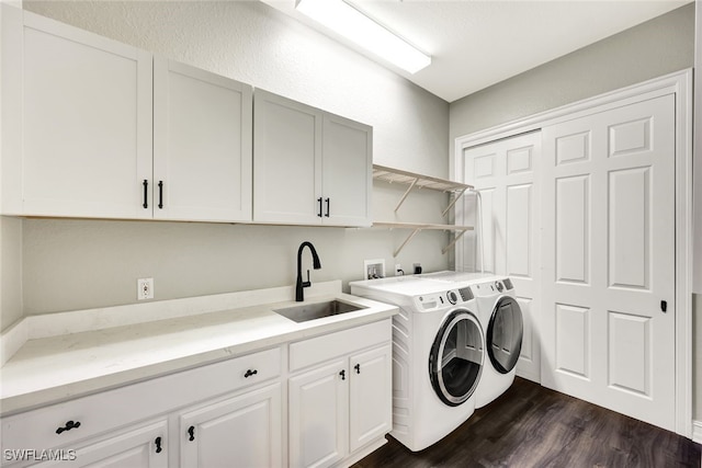 clothes washing area with cabinets, dark hardwood / wood-style floors, washer and clothes dryer, and sink