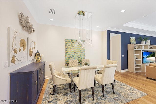 dining area featuring wood-type flooring and ornamental molding